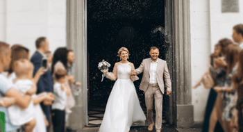 a bride and groom surrounded by their loved ones as they walk down the aisle